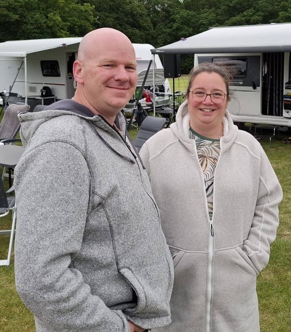 Twee kampeerders bij de caravans